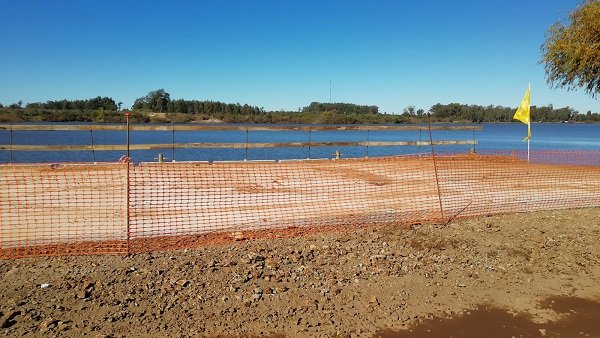 Plataforma a orillas del río Negro de donde embarcarán materiales para el nuevo puente 
